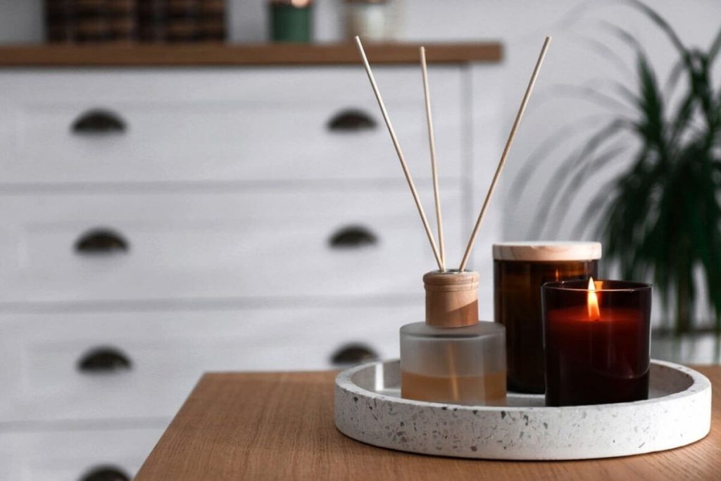 A minimalist side table styled with delicate candles and a diffuser, bringing a fresh and inviting spring scent into the living space.