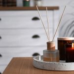 A minimalist side table styled with delicate candles and a diffuser, bringing a fresh and inviting spring scent into the living space.