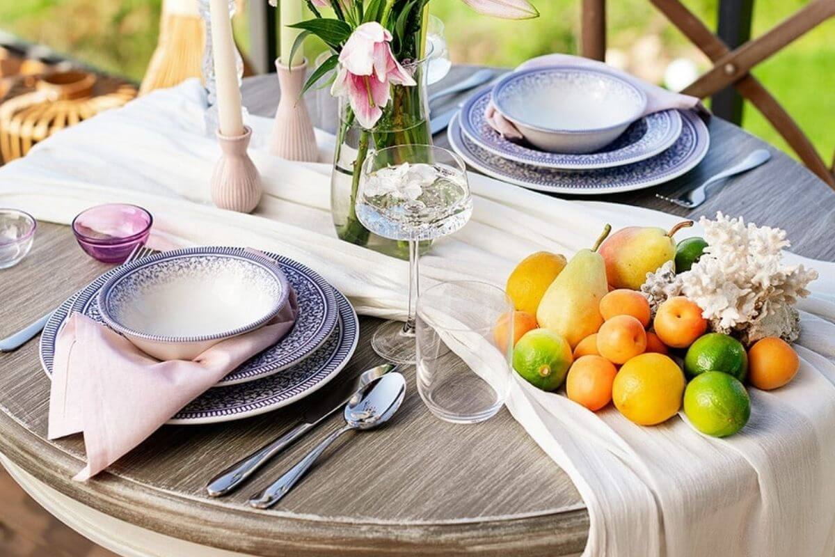 A rustic wooden dining table elegantly styled with delicate flowers and colorful accessories, perfect for spring celebrations.
