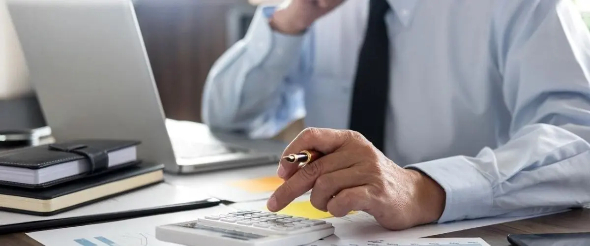Person filling out Turkish tax ID application form at a desk with passport and documents